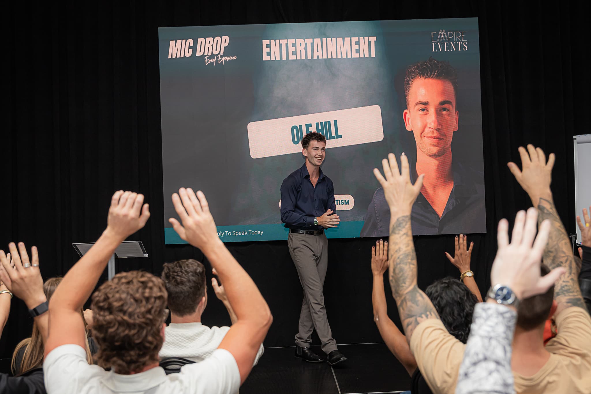 Audience hands raised at Summit Hypnosis event